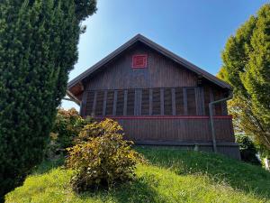a barn with a red window on the side of it at Jazvenik Hill House in Sisak