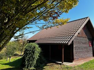 a wooden barn with a roof on a field at Jazvenik Hill House in Sisak