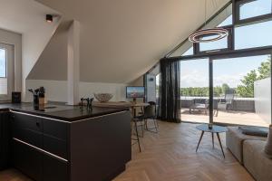 eine offene Küche und ein Wohnzimmer mit großen Fenstern in der Unterkunft Ferienwohnnung Penthouse Schönberg - Kalifornien in Schönberg