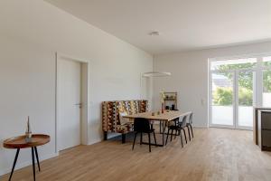 Una sala de estar blanca con una mesa y sillas. en Ferienwohnung Gartenlounge Schönberg - Kalifornien, en Kalifornien 14 fotos más