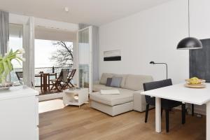 a white living room with a table and a couch at Penthouse Ostseeresidenz in Sassnitz