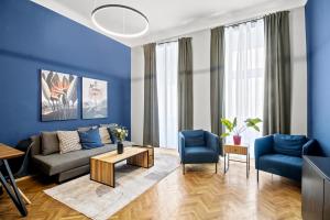 - un salon avec des murs bleus, un canapé et des chaises dans l'établissement Augarten Suites I 5 min to Metro I 10 Min to City, à Vienne