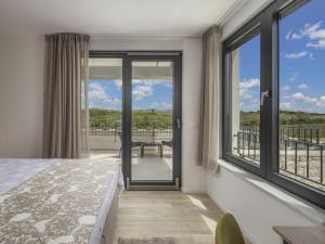 a bedroom with a bed and a balcony withwindows at Villa Alba by Interhome in Brtonigla +36 photos