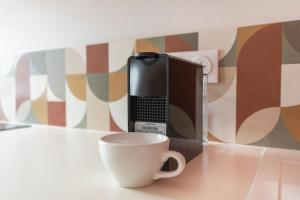 アンジェにあるLa bulle Place du Ralliementのデスク(コーヒーカップ付)、コンピュータ、電話が備わります。