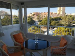 a room with a table and chairs and windows at El buen sol de la manga in La Manga del Mar Menor