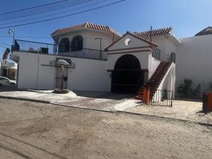 a large white building with a staircase in front of it at Crash & Go - Hotel Style Room in San Felipe