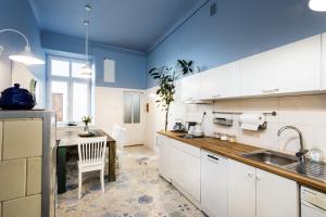 a kitchen with white cabinets and a blue ceiling at Apartment Bernardynska in Krakow