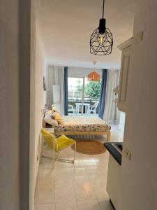 a living room with a bed and a yellow chair at 222 Puerto de la Cruz in Puerto de la Cruz