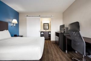 a hotel room with a bed and a desk and a chair at Baymont by Wyndham Kingman in Kingman