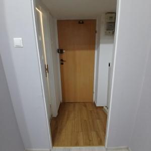 an empty hallway with a door and a wooden floor at Mała kawalerka Kraśnik in Kraśnik
