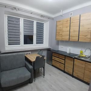 a kitchen with a table and a chair and a sink at Mała kawalerka Kraśnik in Kraśnik