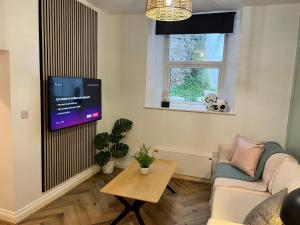 トーキーにあるHeart of Torquay by harbourside, perfect location!のソファと壁掛けテレビのあるリビングルーム