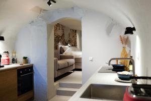 a kitchen with a sink and a living room at Domnacht aan de gracht in Utrecht