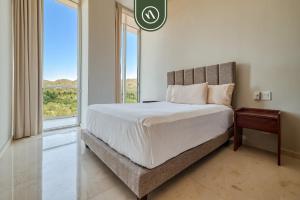ein Schlafzimmer mit einem großen Bett mit einem großen Fenster in der Unterkunft Oceanview Penthouse in Punta Mita - Beach - Pools in Higuera Blanca + 64 Fotos