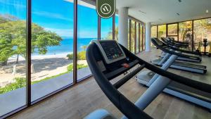 einen Fitnessraum mit einer Reihe von Laufbändern und dem Meer in der Unterkunft Oceanview Penthouse in Punta Mita - Beach - Pools in Higuera Blanca
