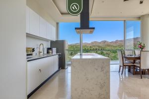 eine Küche mit einem großen Fenster und einem Tisch mit Stühlen in der Unterkunft Oceanview Penthouse in Punta Mita - Beach - Pools in Higuera Blanca