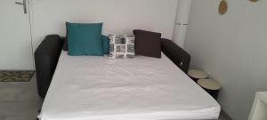 Una cama con sábanas blancas y almohadas en una habitación. en Très beau Studio Cosy à 500m de la Plage, en Gruissan