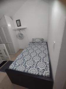 um pequeno quarto com uma cama em um quarto em Duplex playa y mar em Cartagena de Indias