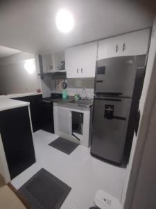 uma cozinha com armários brancos e uma geladeira de aço inoxidável em Duplex playa y mar em Cartagena de Indias mais 19 fotografias