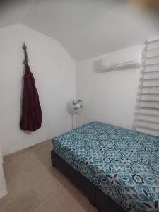 um quarto com uma cama e um vestido pendurado numa parede em Duplex playa y mar em Cartagena de Indias