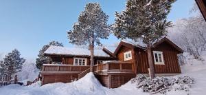 eine Blockhütte im Schnee mit Bäumen in der Unterkunft Malangen Lodge in Mestervik