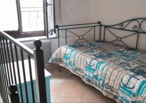 a bedroom with a bed with a quilt on it at Il Grecale - The Cliff Retreat in Corniglia