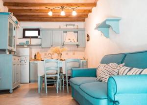 a living room with a blue couch and a kitchen at Il Grecale - The Cliff Retreat in Corniglia