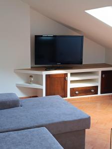 ein Wohnzimmer mit einem Flachbildfernseher auf einem Entertainment-Center in der Unterkunft Tralla in Corcubión