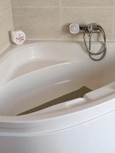 eine weiße Badewanne mit Dusche in der Unterkunft Tralla in Corcubión + 14 Fotos