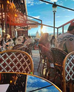 a group of people sitting at an outdoor restaurant at PARIS AUTHENTIC HOUSE Métro 7 Pierre et Marie Curie in Paris
