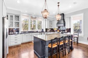 a kitchen with white cabinets and a large island with bar stools at Narnia Grande Pointe Villa - Inlet Beach Pool & Clubhouse Access in Inlet Beach