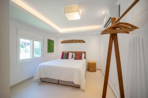 ブジオスにあるBz77 Pé na areia! Casa com jacuzzi e 4 suítesのベッドと窓のある白い寝室