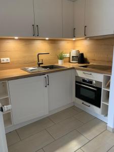 a kitchen with white cabinets and a sink at Fewo 2, Achtern Diek 3a Zingst in Zingst