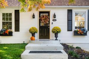 a house with a pumpkin on the front door at Beautiful Benson Cottage with Year-Round Hot Tub in Omaha +41 photos