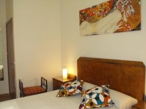塞維利亞的住宿－Karmapartment，卧室配有一张床,墙上挂有绘画作品