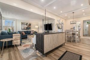 a living room with a blue couch and a tv at Midtown Spot Lovely Fenced Backyard & Hot Tub in Omaha