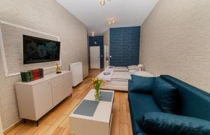 Una sala de estar con un sofá azul y una cama. en Central Apartments Stargard, en Stargard