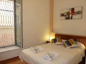 1 dormitorio con 1 cama con 2 almohadas y ventana en Karmapartment, en Sevilla