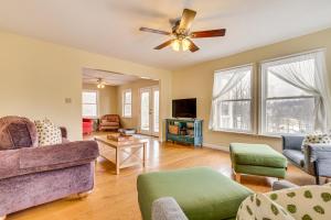 a living room with a couch and a ceiling fan at Family Home with Game Room and Decks in Etlan! in Etlan