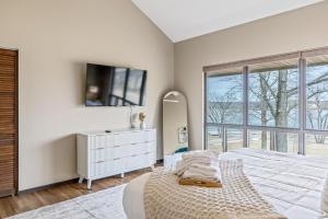 a white bedroom with a bed and a mirror at Lionshead Lake Retreat in Innsbrook