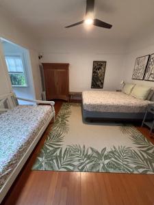 a bedroom with two beds and a ceiling fan at Banyan Tree B&B Retreat in Makawao