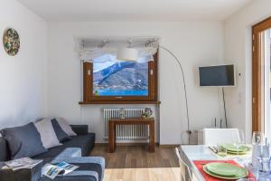 Una sala de estar con un sofá y una ventana. en Apartment Magnolia A - Musso, en Musso