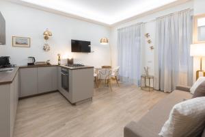 Una sala de estar con cocina y una sala de estar con sofá. en Le Rondini in giardino, en Roma