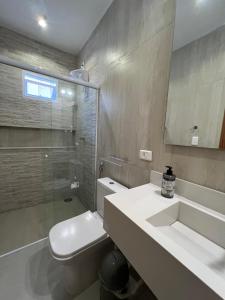 a bathroom with a toilet and a sink and a shower at Casa Vivá Guaeca in São Sebastião +51 photos