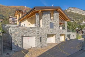 una casa con garaje y un edificio de piedra en Apartment Magnolia A - Musso, en Musso
