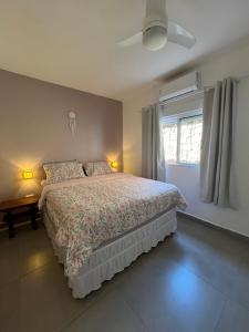a bedroom with a bed and a window at Casa Vivá Guaeca in São Sebastião