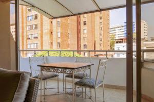 a table and chairs on a balcony with a view at Hotel Riviera Plaza in Bucaramanga