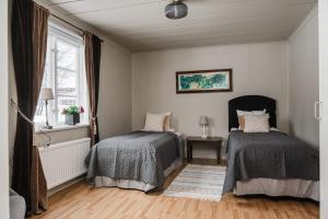 a bedroom with two beds and a window at Gasabäck Holiday Accomondation in Söråker +12 photos