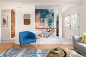 a living room with a blue chair and a couch at Peaceful Gem HotTub Fenced Yard & Near Downtown in Omaha