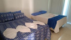 two beds with towels on them in a room at Flat Club meridional B3 1ps in Tamandaré +15 photos